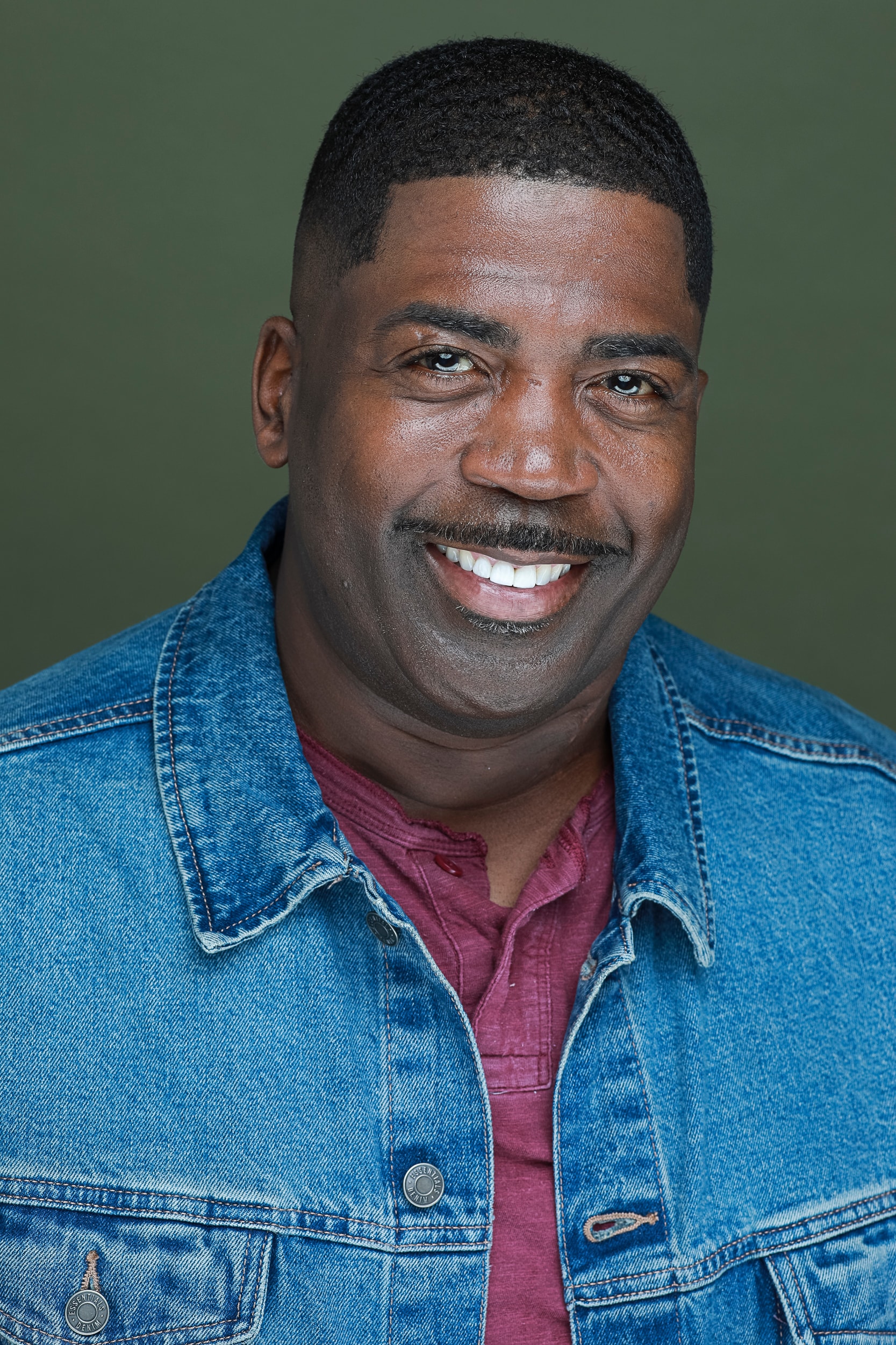 Robert Déon smiling portrait green background